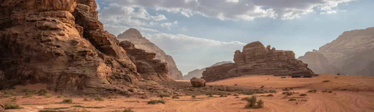 ירדן: Scenic desert landscape with rock formations and cloudy sky in Wadi Rum, Jordan.