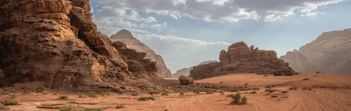 ירדן: Scenic desert landscape with rock formations and cloudy sky in Wadi Rum, Jordan.