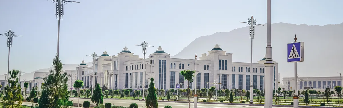 טורקמניסטן: Elegant white government building with ornate lamp posts in Ashgabat.