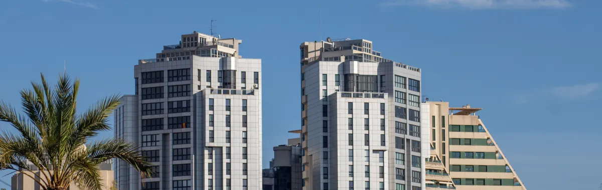 View of modern skyscrapers surrounded by greenery in Valencia, Spain under a clear blue sky.