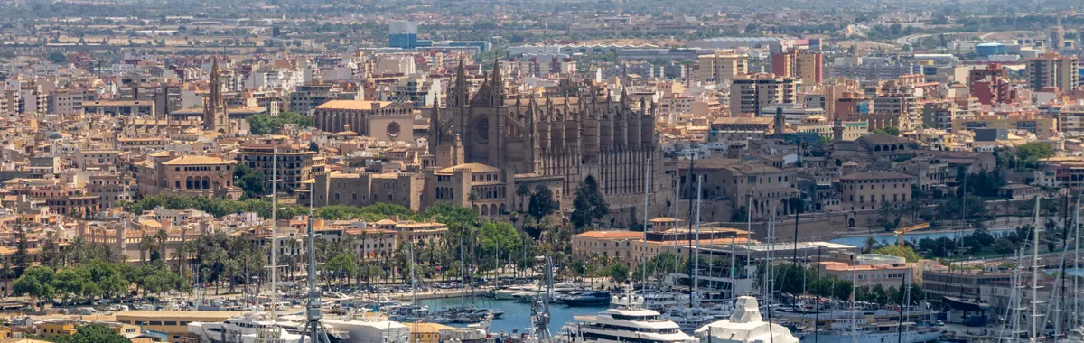 Explore the picturesque skyline of Palma de Mallorca featuring La Seu Cathedral and the bustling marina.