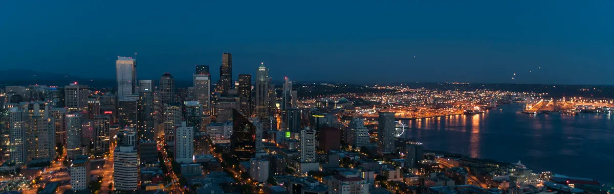 A breathtaking view of Seattle's skyline at twilight with city lights illuminating the urban landscape.