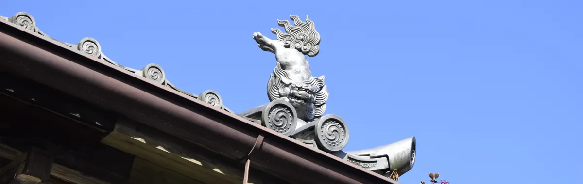 Intricate roof ornamentation against a clear blue sky in Sendai, Japan.