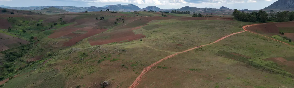 מלאווי: Breathtaking aerial view of Malawi's expansive green and brown highlands under a vibrant, cloud-filled sky.