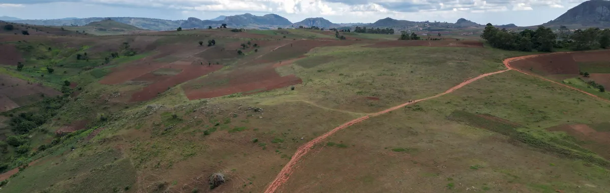 מלאווי: Breathtaking aerial view of Malawi's expansive green and brown highlands under a vibrant, cloud-filled sky.