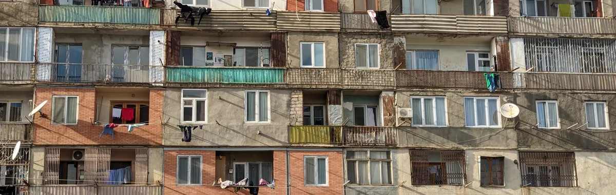 Exterior view of a multi-story apartment building in Rustavi, showcasing varied architecture and balconies.