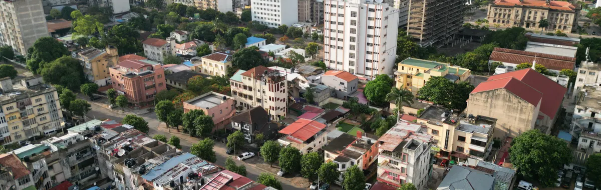 Aerial view of Maputo's urban landscape with buildings and coastline.