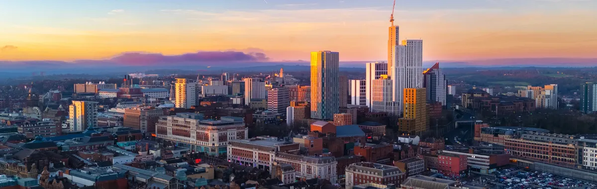 Stunning aerial view of Leeds city skyline in England during sunset with vibrant colors.