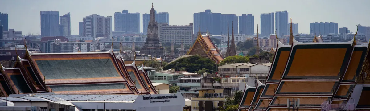תאילנד: Skyline view of Bangkok highlighting traditional Thai architecture amidst modern buildings.