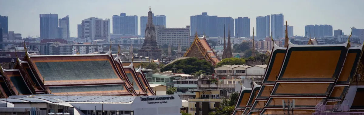 תאילנד: Skyline view of Bangkok highlighting traditional Thai architecture amidst modern buildings.