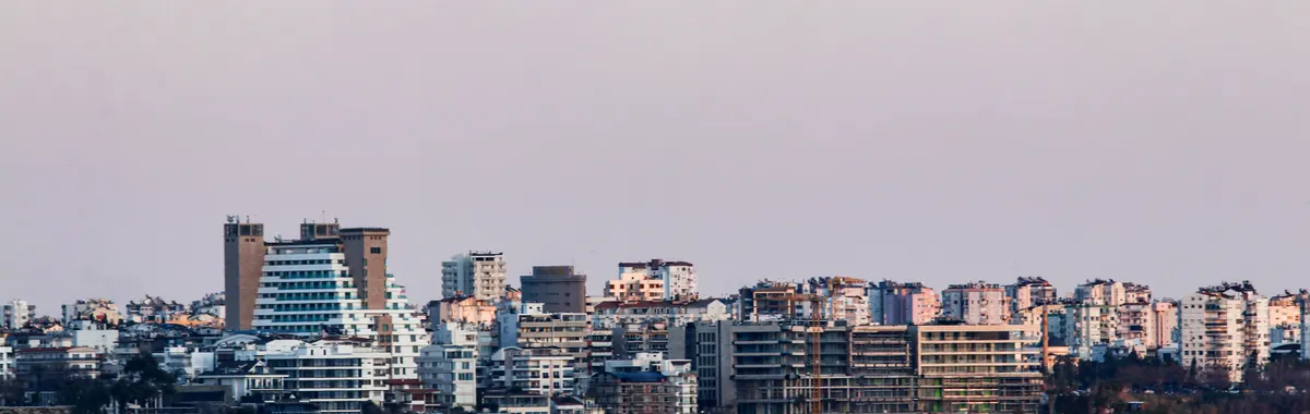 Stunning view of Antalya skyline at dusk, with buildings along the coast and a serene sea.