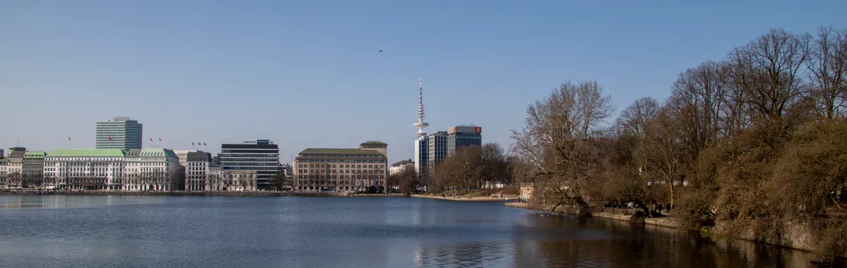 A beautiful view of the Binnenalster lake in Hamburg with clear blue skies and iconic landmarks.