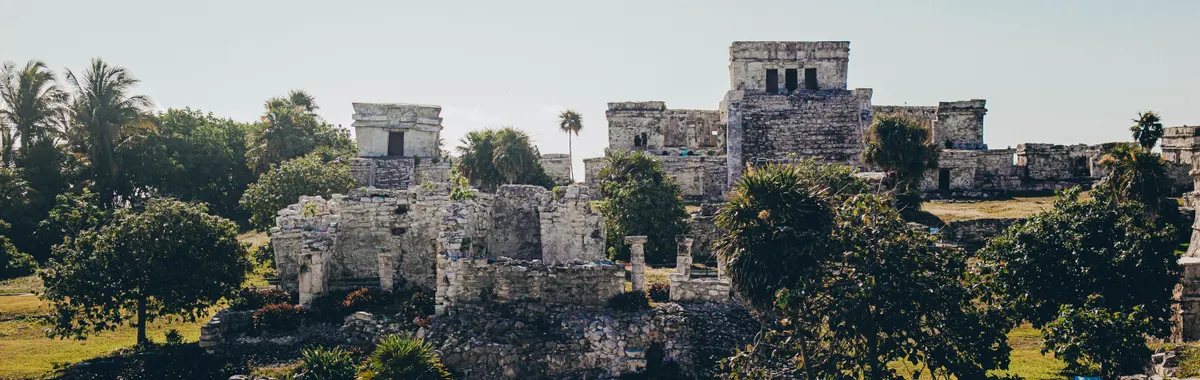 Explore the stunning Mayan ruins of Tulum against a clear blue sky.
