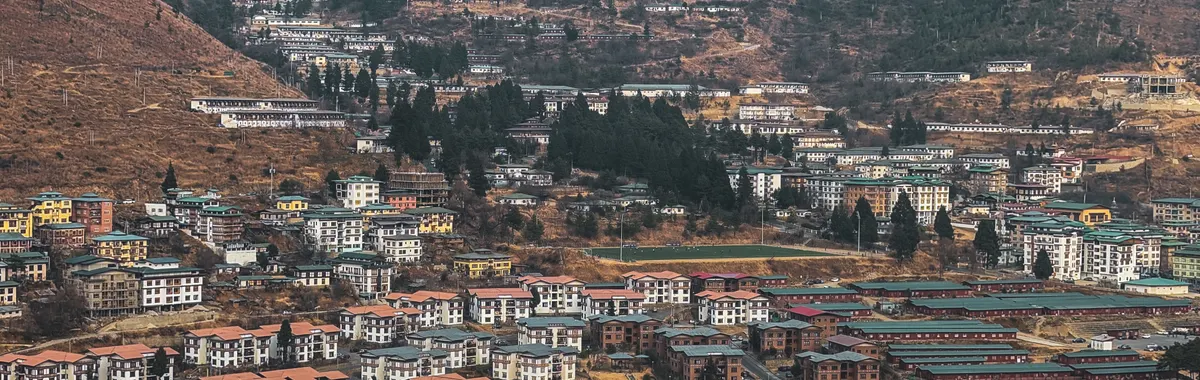 Aerial view of Thimphu city nestled in Bhutan's mountain landscapes, showcasing unique architecture and scenic beauty.