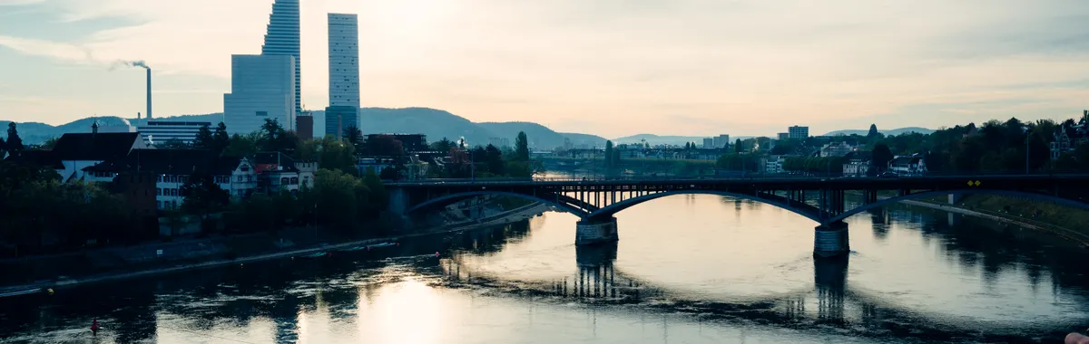 Captivating view of Basel's skyline and the Rhine River at sunset, showcasing modern architecture.
