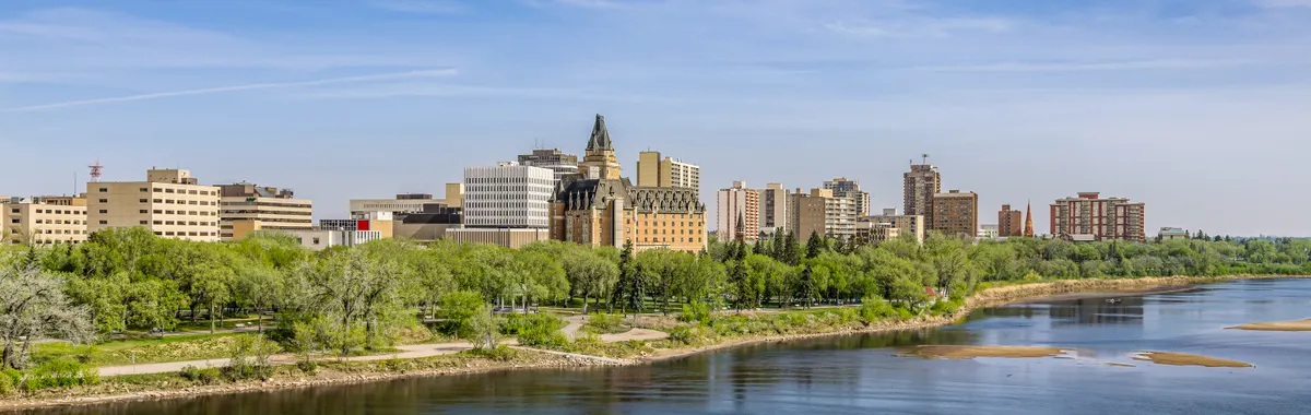 A beautiful spring view of Saskatoon cityscape with a river and reflections.