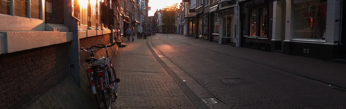 Sunlit street in Haarlem, Netherlands at sunset with bicycles and historic architecture.