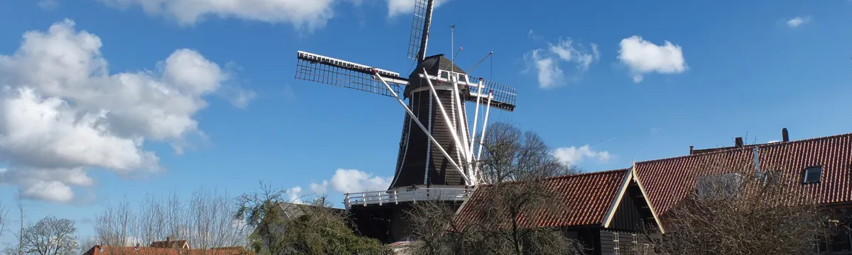 הולנד: A scenic view of a traditional windmill in Hattem, Gelderland on a sunny day.