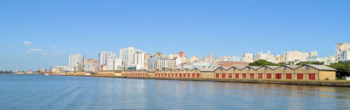 Panoramic view of Porto Alegre's skyline along the waterfront under a clear blue sky.