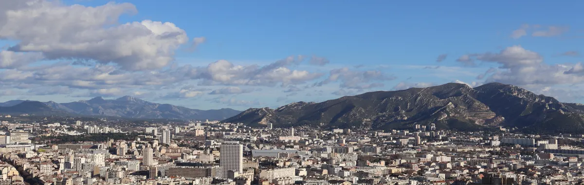 A stunning aerial view of the cityscape of Marseille, France, under a bright summer sky.