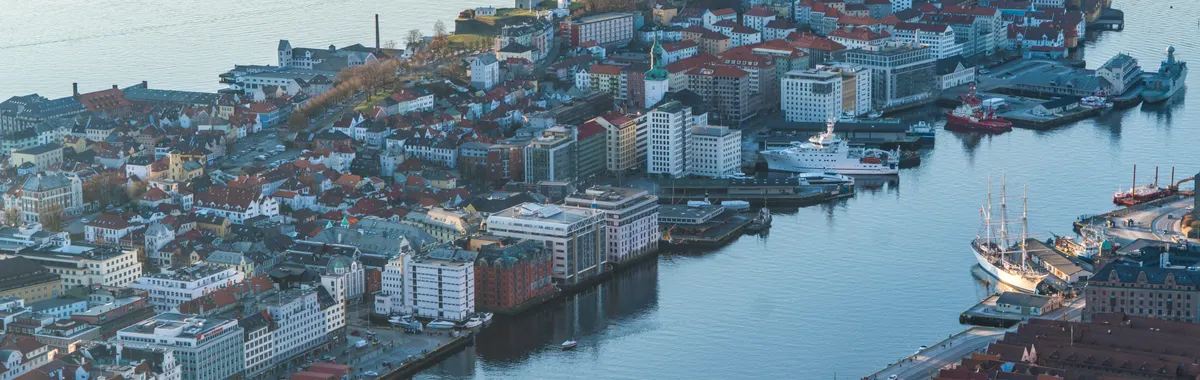 A breathtaking aerial shot of Bergen, Norway, showcasing the harbor and cityscape with boats and waterfront buildings.