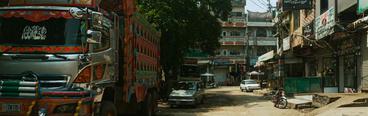 Vibrant decorated truck parked on a bustling Rawalpindi street. Captured with dynamic urban scenery.