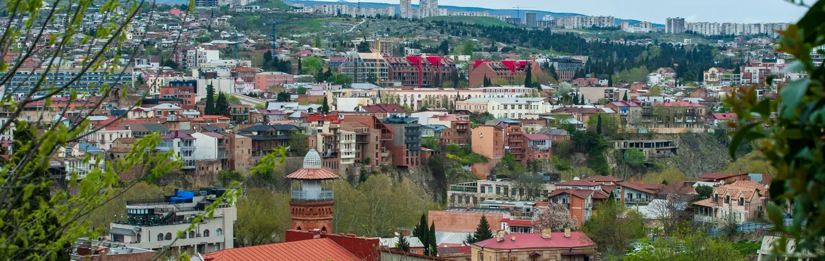 Explore the stunning urban landscape of Tbilisi, Georgia with lush greenery and traditional architecture.
