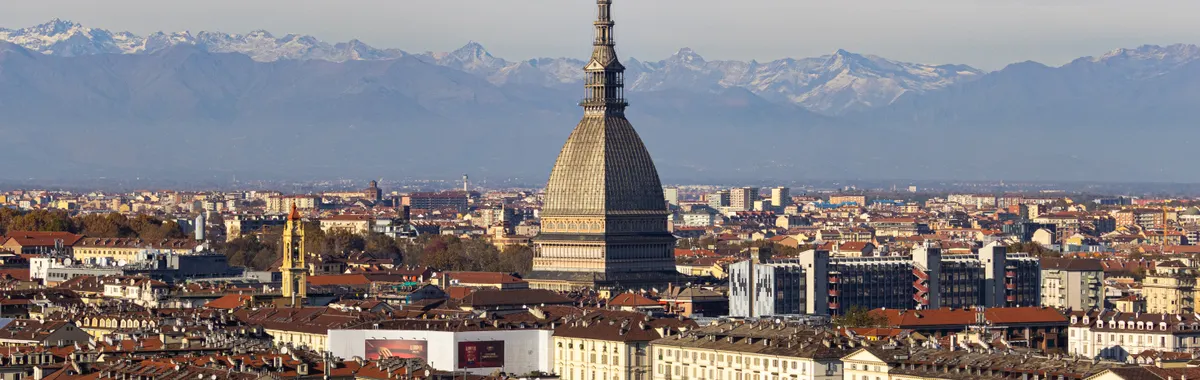 Discover the stunning cityscape of Turin with the iconic Mole Antonelliana and the Alps in the background.