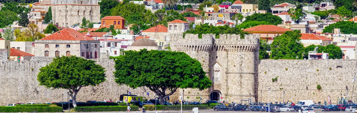 Beautiful view of the historic fortress in Rhodes, Greece, with vibrant cityscape and waterfront.