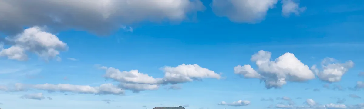 קלדוניה החדשה: Breathtaking view of mountains and clouds in New Caledonia with clear blue sky.