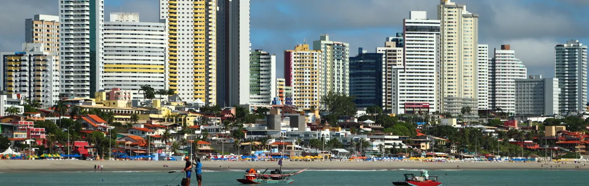 Vibrant skyline of Natal, Brazil with fishermen at the beach. Captivating seascape with tall buildings.