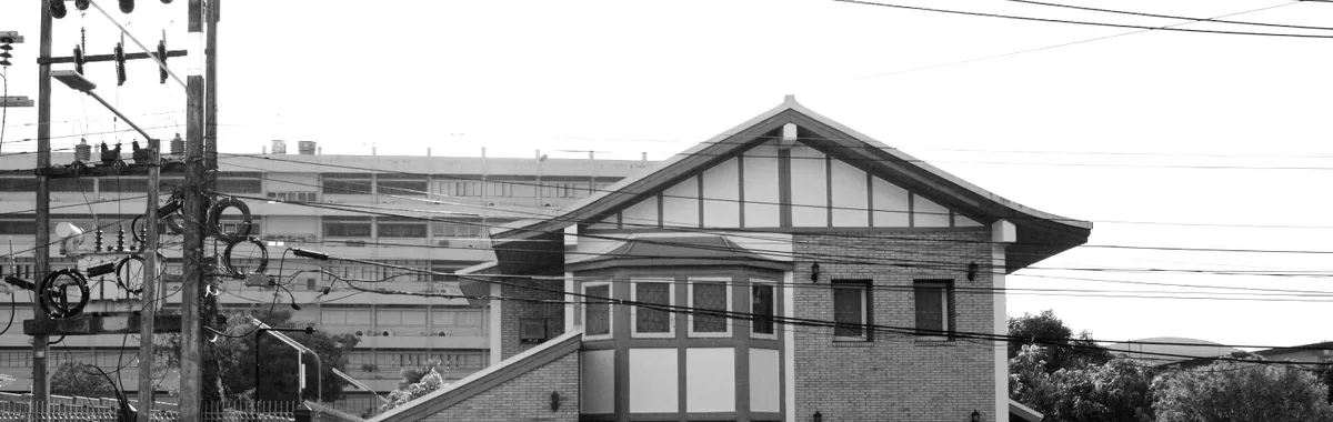 Black and white photo of a brick house with electric cables in Hat Yai, Thailand.