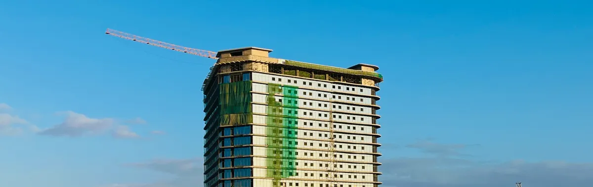 A tall building under construction in Mogadishu, showcasing the skyline against a clear blue sky.