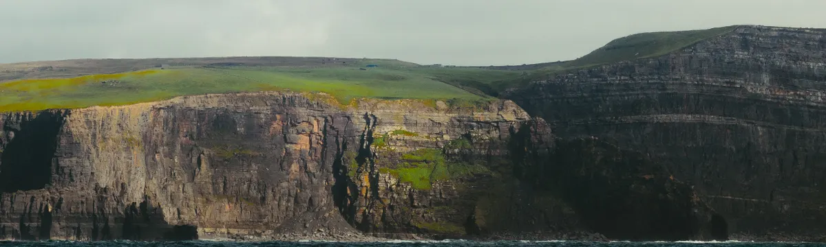 אירלנד: Majestic cliffs of Inishmore, County Galway, rising above turbulent waters.