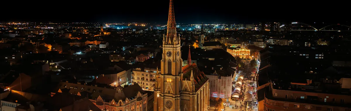 A stunning aerial night view of the illuminated Novi Sad Cathedral in Serbia.