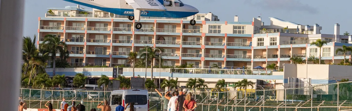 סנט מארטן: A plane flies low over tourists at Maho Beach, Sint Maarten, near the airport.
