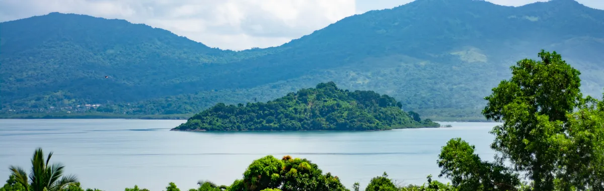 מאיוט: Beautiful landscape of an islet surrounded by the Indian Ocean in Mayotte, showcasing lush greenery and mountains.