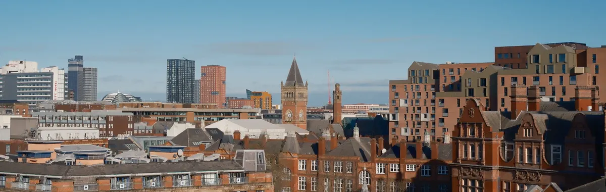 A vibrant view of Manchester showcasing modern and classic architecture under a clear sky.