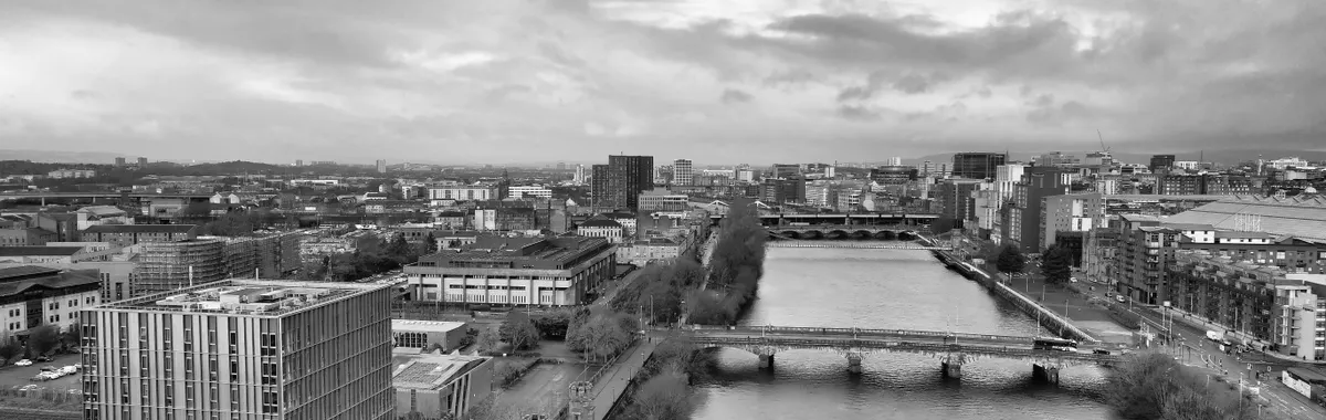 Black and white aerial cityscape of Glasgow featuring the River Clyde and surrounding architecture.