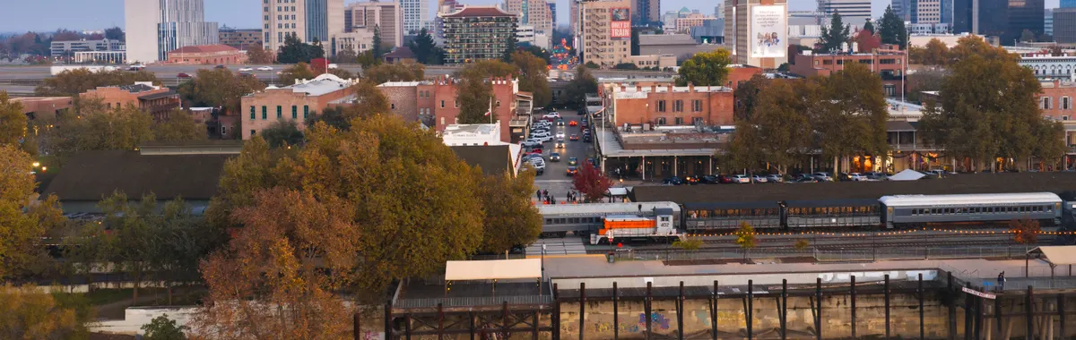 A beautiful twilight aerial view of Sacramento's urban skyline with historic Old Sacramento in foreground.