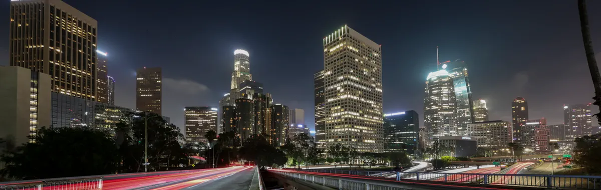 Vibrant long exposure of Downtown Los Angeles skyscrapers at night, showcasing the city skyline.