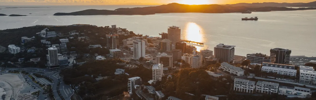 Stunning aerial view of Port Moresby skyline at sunset, featuring coastal beauty and urban landscape.