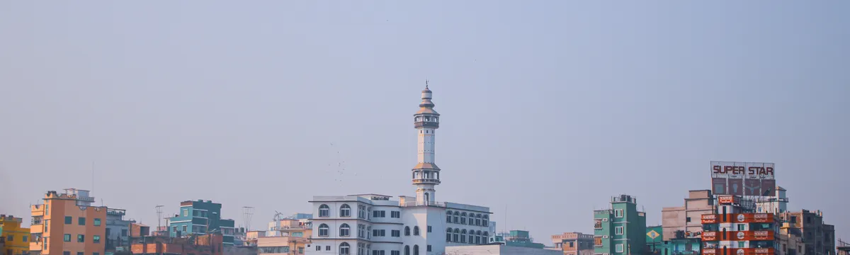 בנגלדש: View of colorful buildings and mosque along riverbank in Dhaka, Bangladesh.