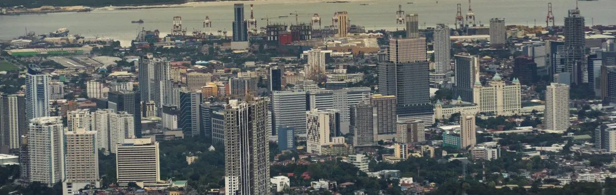 Panoramic view of Cebu City showcasing high-rise buildings and urban landscape with waterfront.