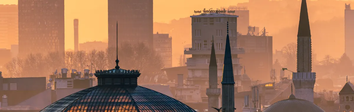 Golden hour view of Sarajevo skyline with notable landmarks in evening light.