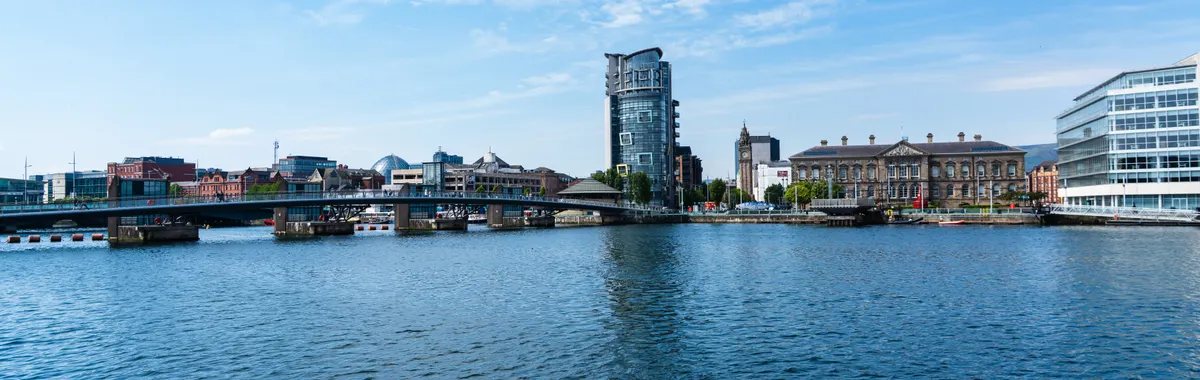 View of the Lagan River with the Belfast skyline, showcasing modern and historic architecture.