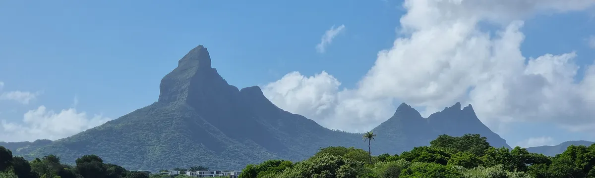 מאוריציוס: Capture of Mauritius' iconic mountains and lagoon under clear blue sky.