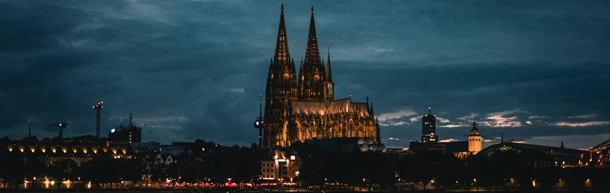 Stunning night view of Cologne Cathedral, reflecting over the Rhine River in Köln, Germany.