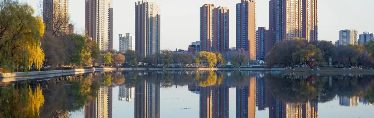 Stunning skyline of Shenyang reflected in a serene lake, capturing urban symmetry and autumn colors.