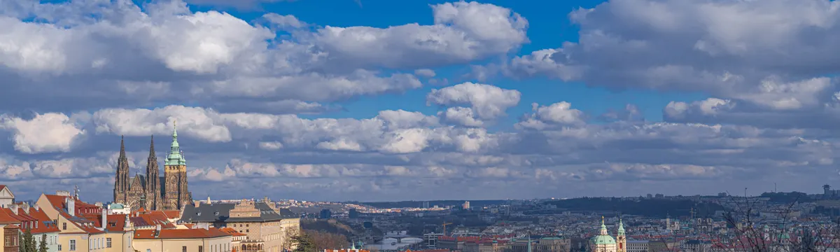 צ׳כיה: Breathtaking panorama of Prague featuring St. Vitus Cathedral and classic architecture under a vibrant sky.